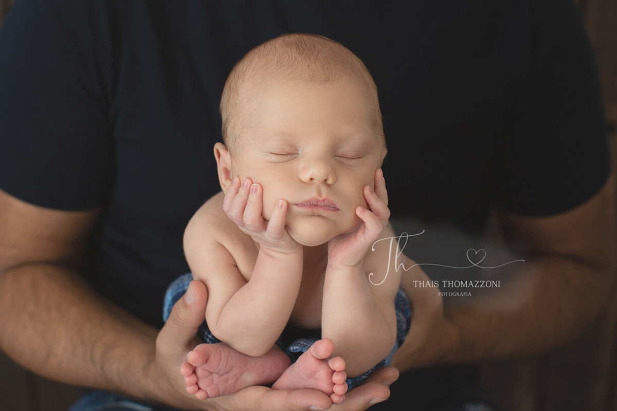 foto newborn na mão do papai