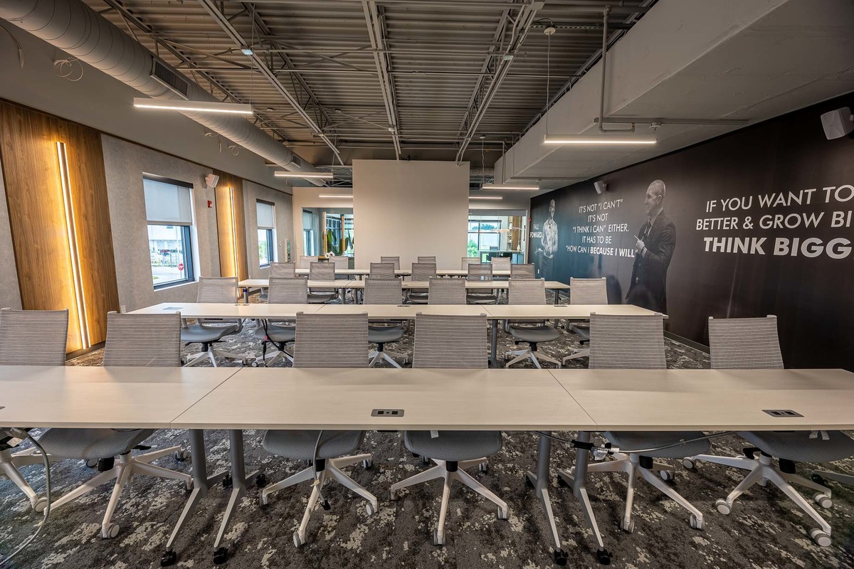 Spacious training room in Orlando, FL designed with modern furniture and motivational décor, ideal for interior and real estate photography. Captures a professional and collaborative image