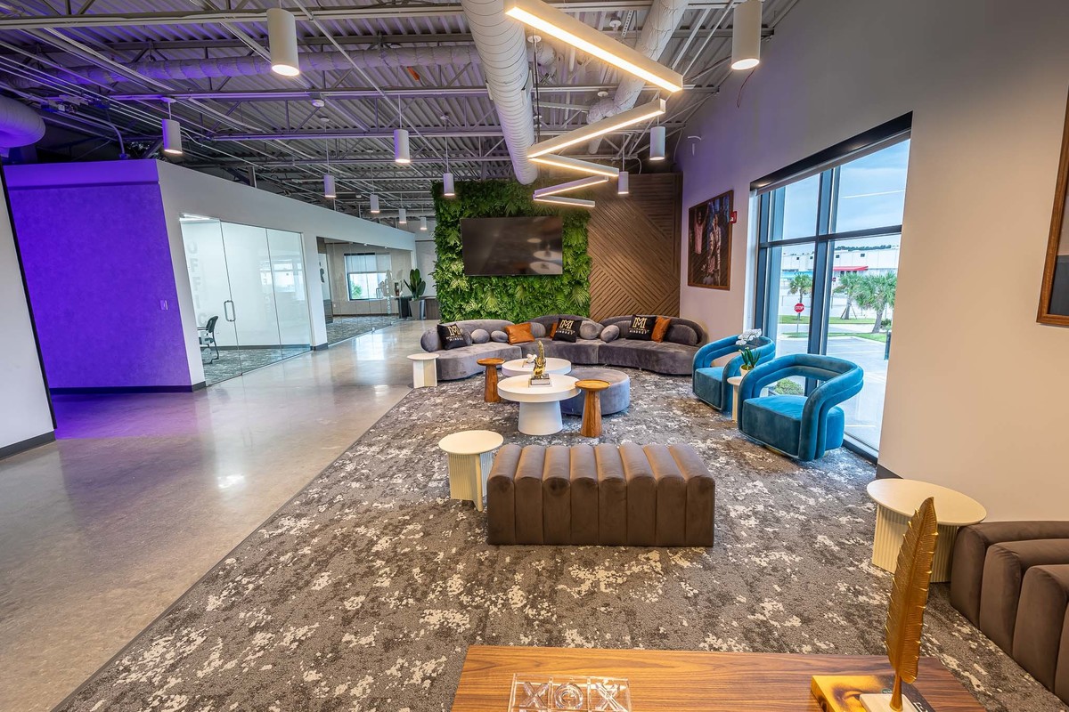 Stylish office reception in Orlando, FL featuring a lush green wall and contemporary seating, perfect for interior and real estate photography. Presents an inviting and innovative environment
