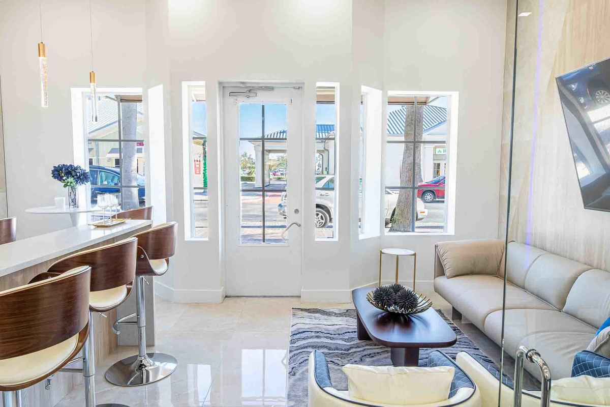 Bright seating area with contemporary furniture, large windows, and natural light creating an inviting and stylish ambiance.