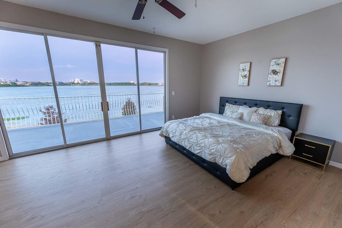 Master bedroom with panoramic lake views in Orlando, showcasing a modern and cozy design.