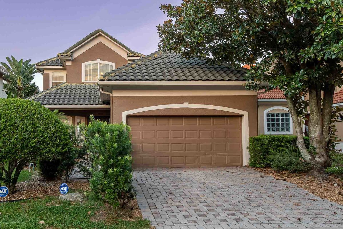 Exterior photography of an Orlando residence highlighting the well-maintained garage and garden.