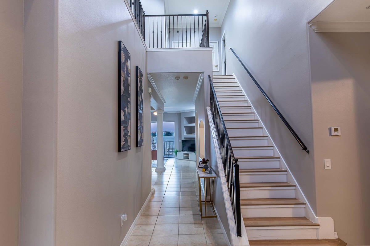 Elegant hallway with a staircase and black accents, lit and photographed in Orlando.