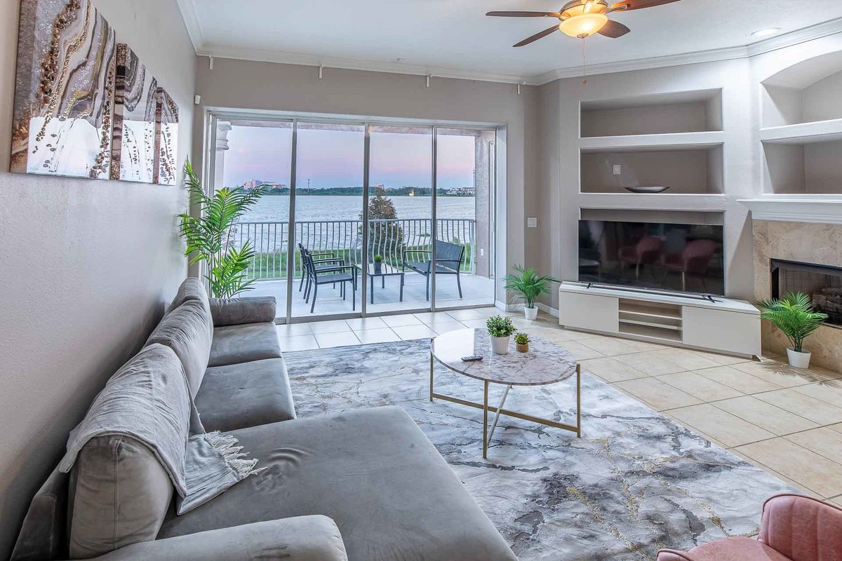 Twilight view of a living room in Orlando, with modern details and a large window facing the lake, photographed to emphasize the cozy ambiance.