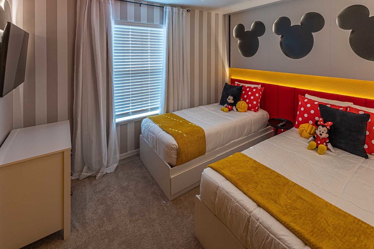 Disney-inspired Kids' Room: Perfectly capturing the joy of Disney, this photograph illustrates a brightly decorated kids' room with iconic Mickey Mouse motifs, designed by architects for a fun-filled Orlando vacation experience.
