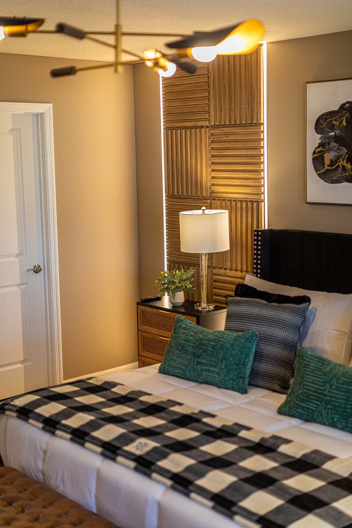 Dramatically Lit Bedroom: Interior photography highlights a bedroom with dramatic lighting and contemporary decor, with a large painting over the bed adding an artistic touch to the environment.