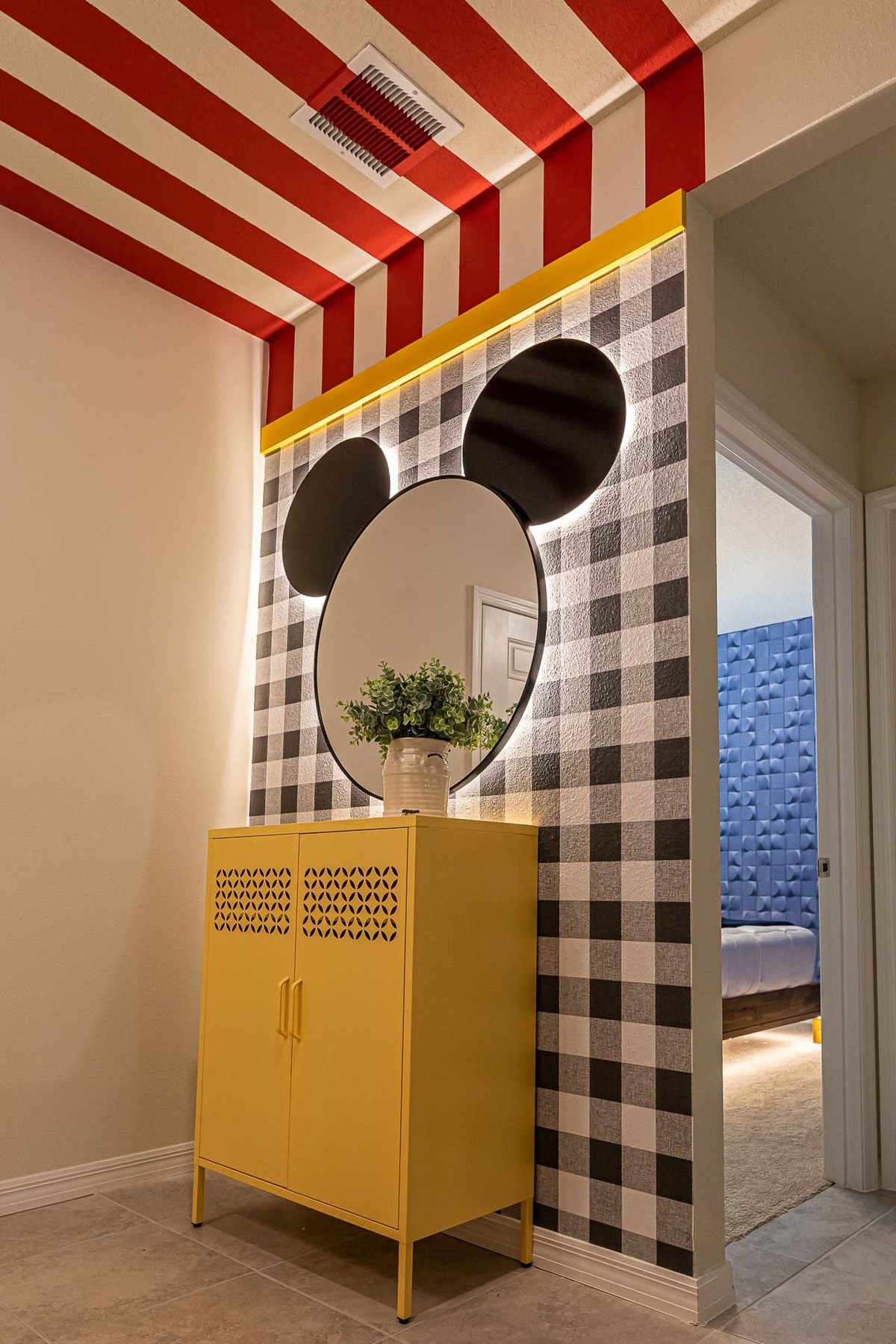 Playful and Chic Hallway Design: Featuring whimsical wall decor and a vibrant yellow cabinet, this photo highlights the architects' playful approach to designing vacation homes in Orlando.
