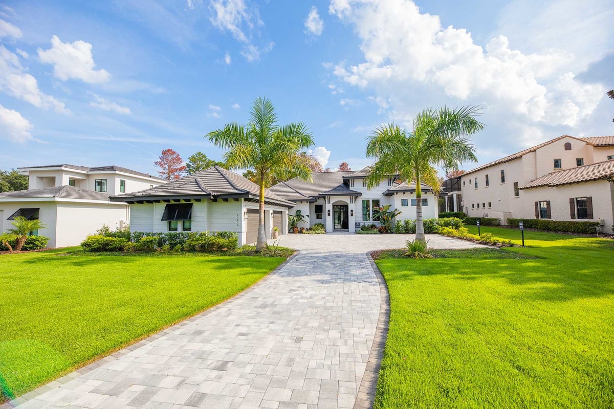 Facade of a beautiful property located in the Orlando area, FL, with a lawn and pine trees. Magic Lens Photo Media.