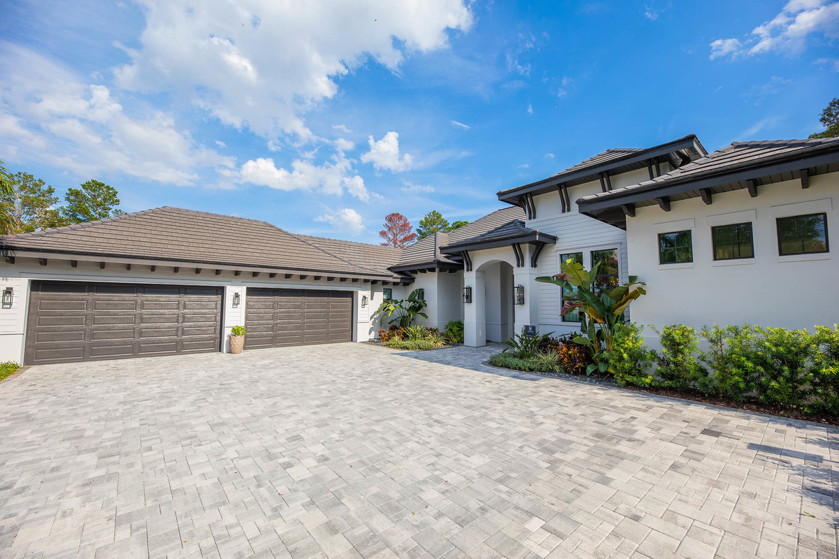 Facade of a beautiful property located in the Orlando area, FL, with a lawn and pine trees. Magic Lens Photo Media.