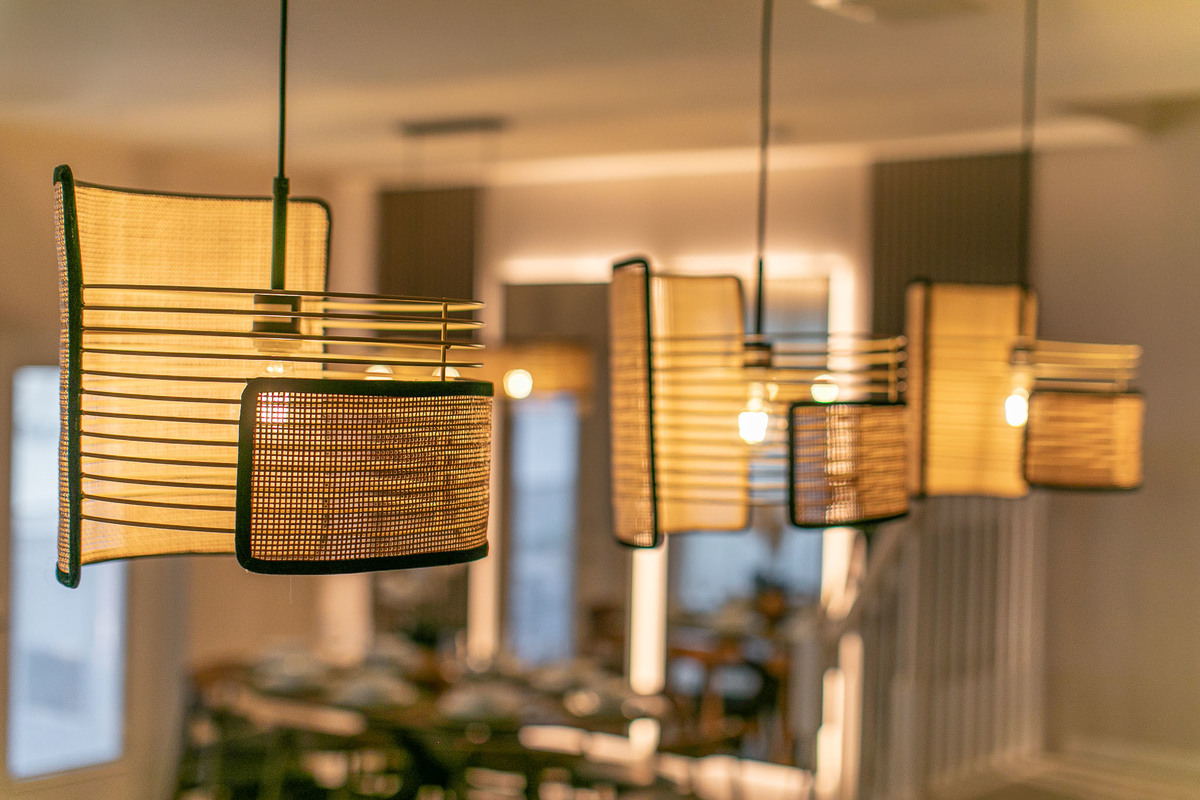 Close-up of elegant rattan pendant lights with a warm glow, giving the room a cozy ambiance.