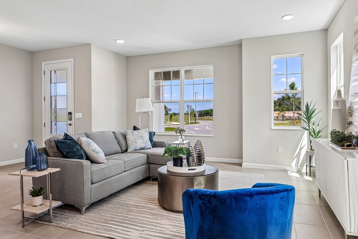 bright-living-room-gray-sofa-blue-velvet-chair-large-windows-natural-light-5348-ctr-lk-rnch-blvd-st-cloud-fl