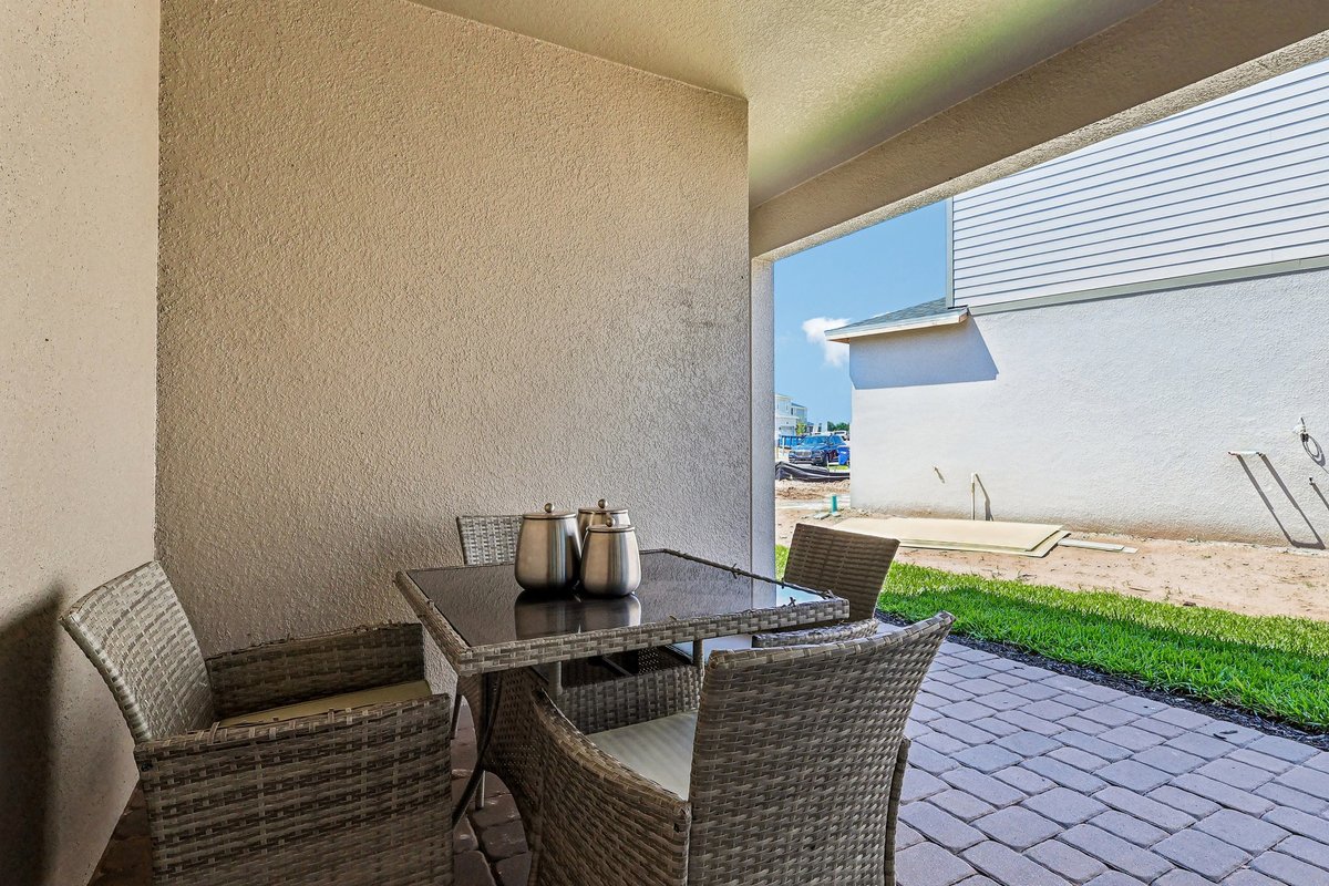 covered-patio-outdoor-dining-set-backyard-green-lawn-new-construction-community-5348-ctr-lk-rnch-blvd-st-cloud-fl