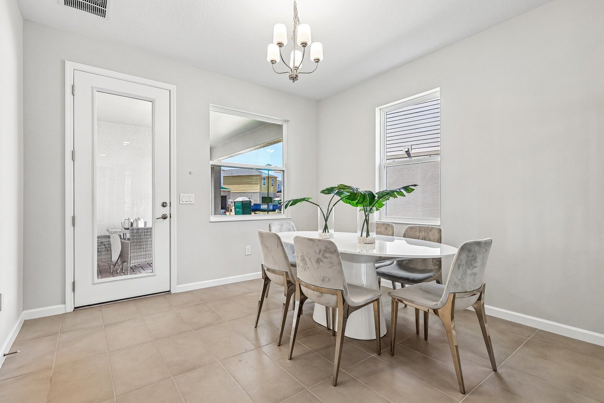dining-area-white-round-table-velvet-chairs-chandelier-glass-patio-door-natural-light-5348-ctr-lk-rnch-blvd-st-cloud-fl