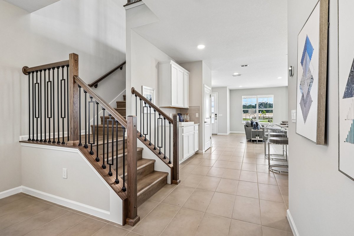 elegant-wood-staircase-iron-balusters-open-foyer-modern-wall-art-tile-flooring-5348-ctr-lk-rnch-blvd-st-cloud-fl