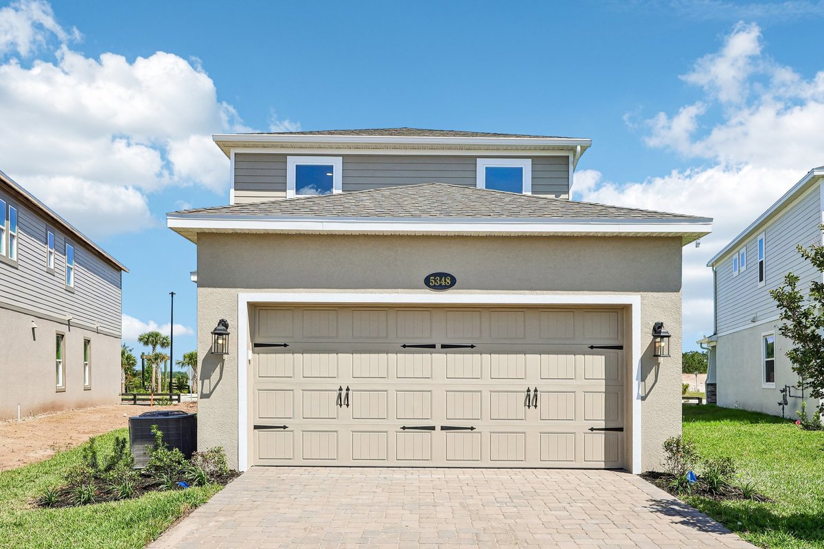 front-elevation-two-car-garage-paver-driveway-gray-siding-stucco-new-construction-5348-ctr-lk-rnch-blvd-st-cloud-fl