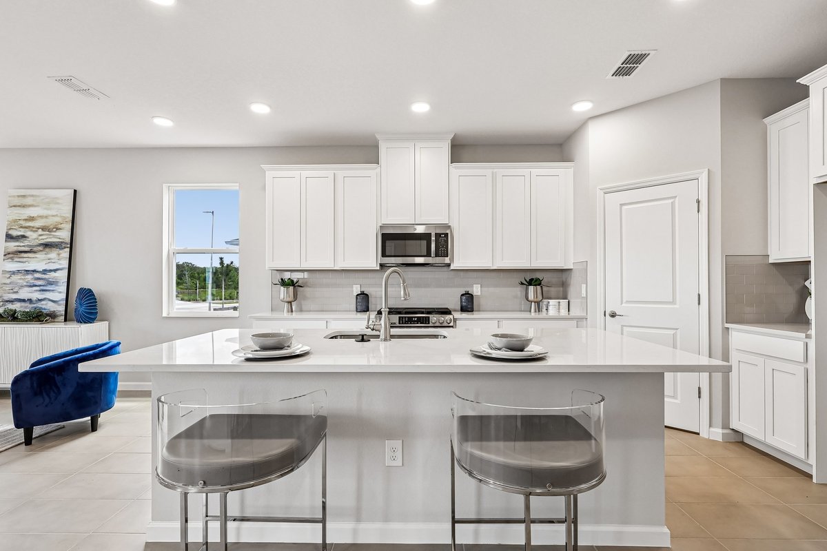 kitchen-island-with-quartz-countertop-acrylic-bar-stools-white-cabinets-stainless-appliances-5348-ctr-lk-rnch-blvd-st-cloud-fl