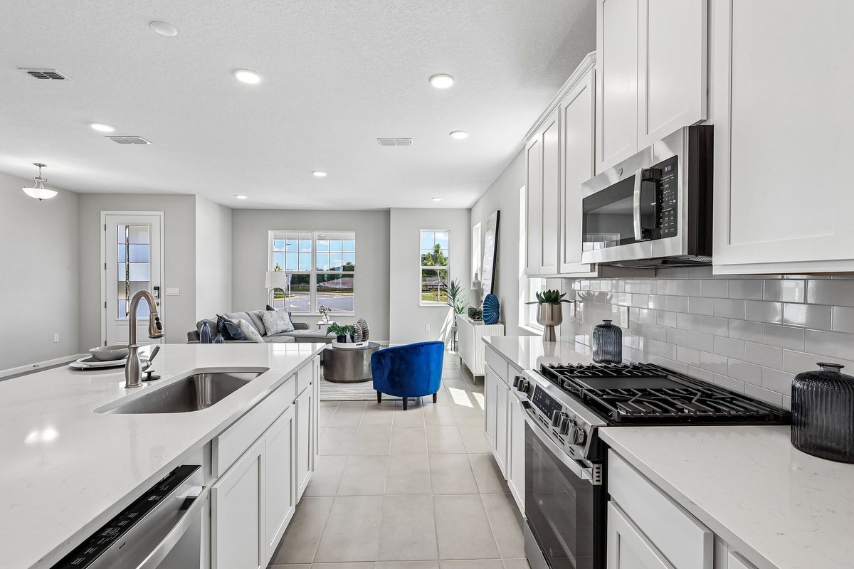 kitchen-view-toward-living-room-white-cabinets-gas-range-subway-tile-blue-accent-chair-5348-ctr-lk-rnch-blvd-st-cloud-fl