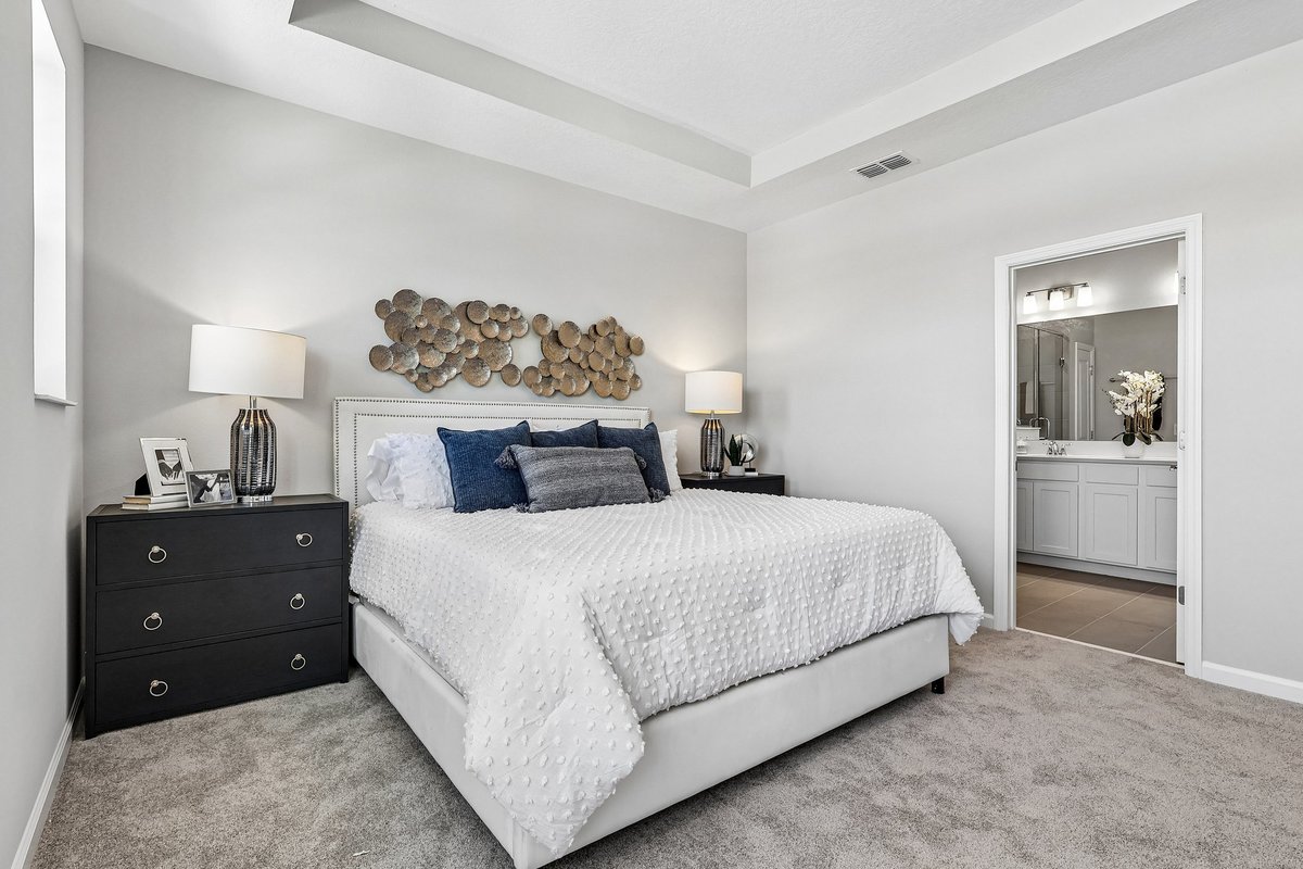 master-bedroom-king-bed-tray-ceiling-ensuite-bathroom-view-metal-wall-art-navy-pillows-5348-ctr-lk-rnch-blvd-st-cloud-fl