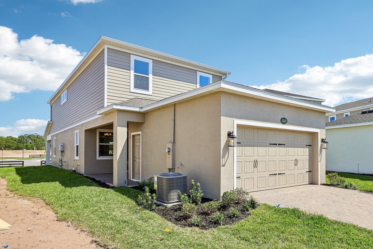 two-story-home-rear-exterior-two-car-garage-gray-siding-stucco-landscaping-5348-ctr-lk-rnch-blvd-st-cloud-fl