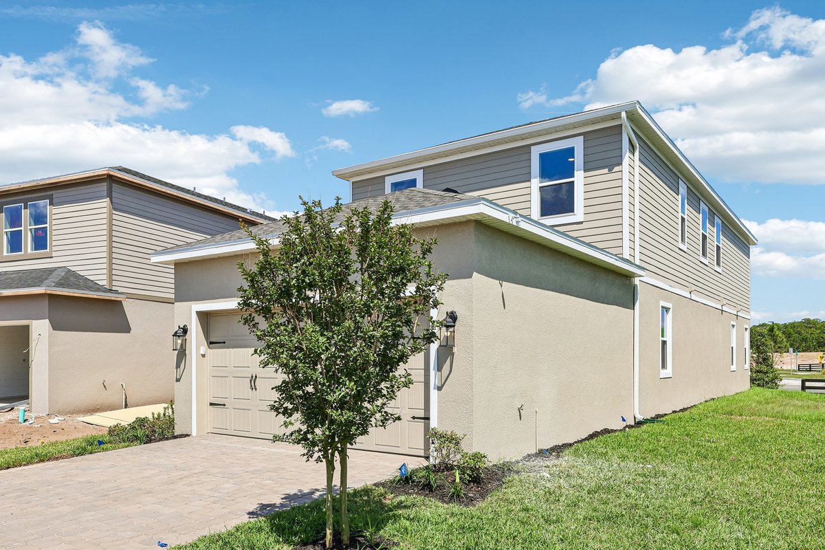 two-story-new-construction-side-view-gray-siding-stucco-paver-driveway-landscaping-5348-ctr-lk-rnch-blvd-st-cloud-fl