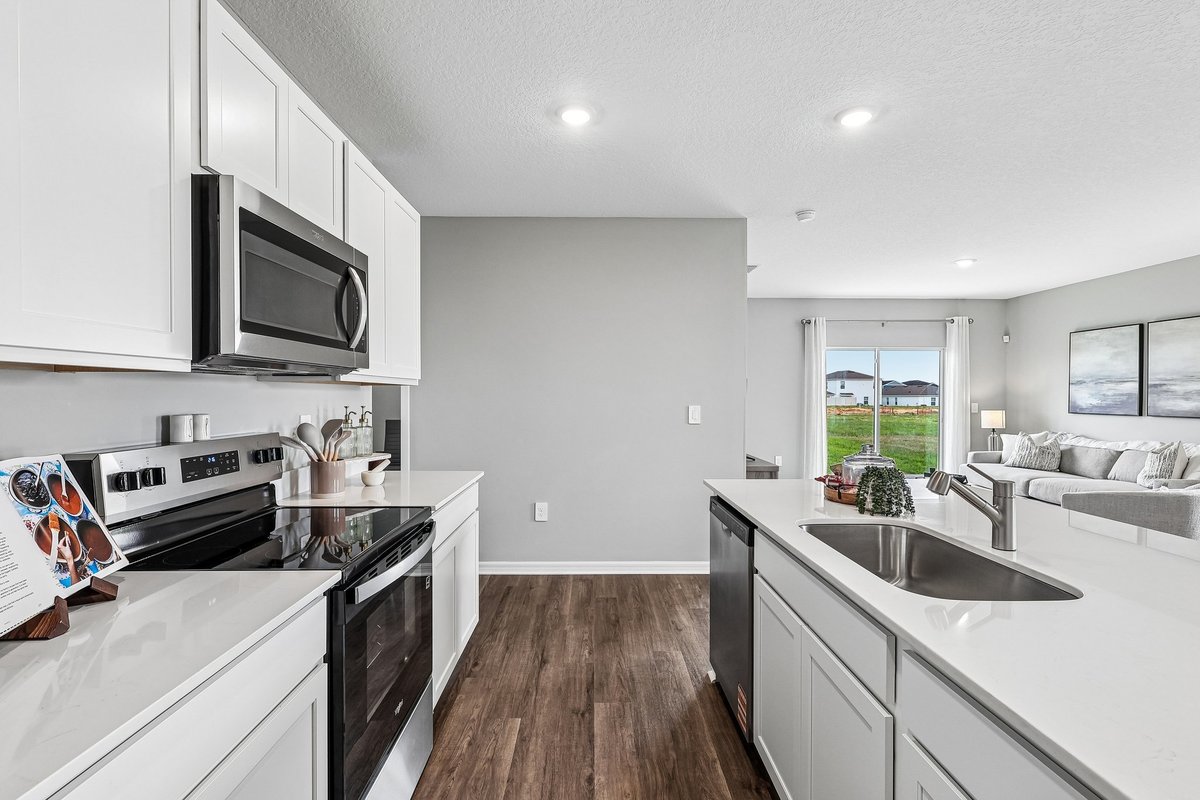 Modern kitchen with quartz countertops and a spacious island in a new construction home.