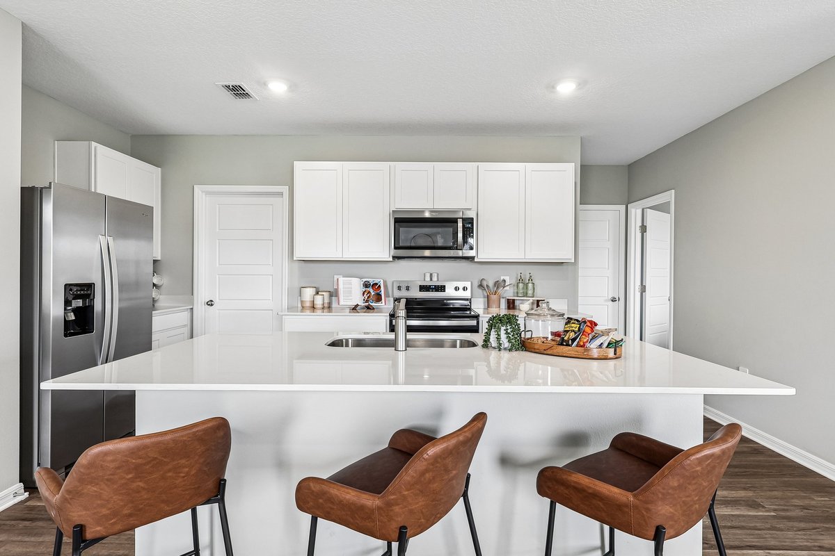 Modern kitchen with quartz countertops and a spacious island in a new construction home.