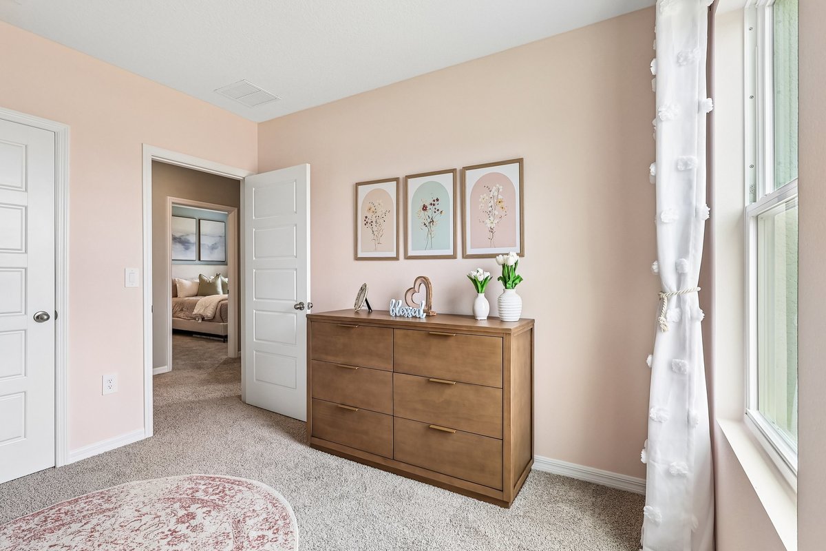 Bright secondary bedroom in a professionally staged model home. baby