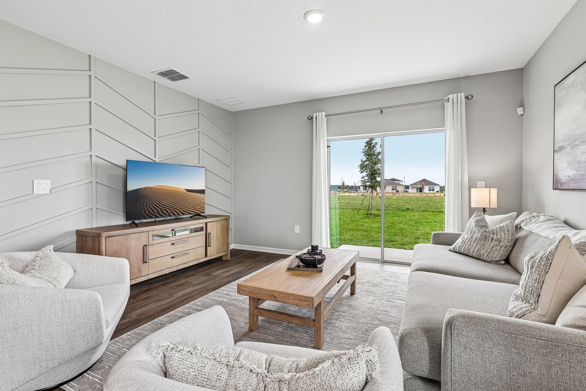 Bright open-concept living room with natural light in a DR Horton model home.