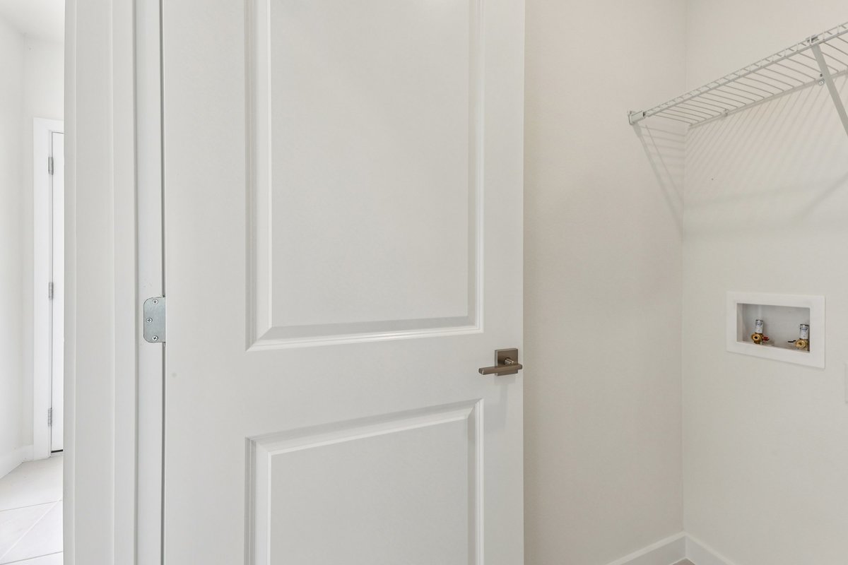 Laundry room with wire shelving in new construction home