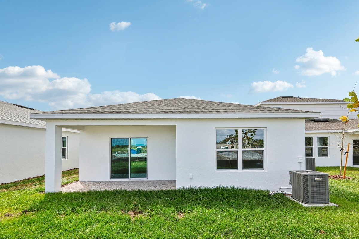 Rear exterior of new construction home with covered patio