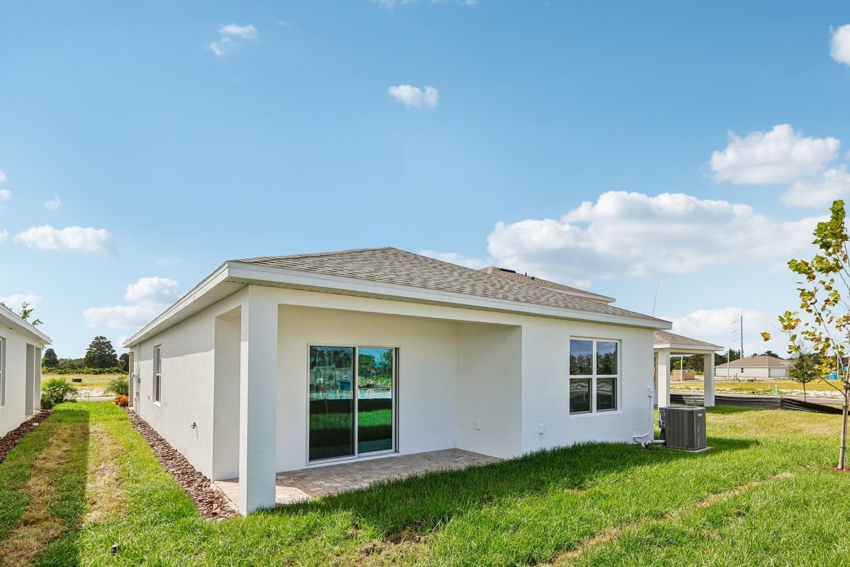 Rear exterior of new construction home with covered patio
