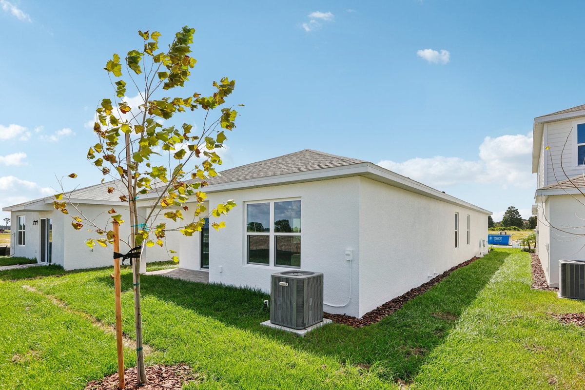 Rear exterior of new construction home with covered patio