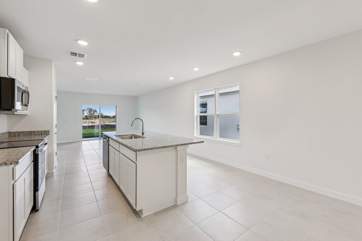 Open kitchen with white cabinets and granite countertops in Winter Haven FL