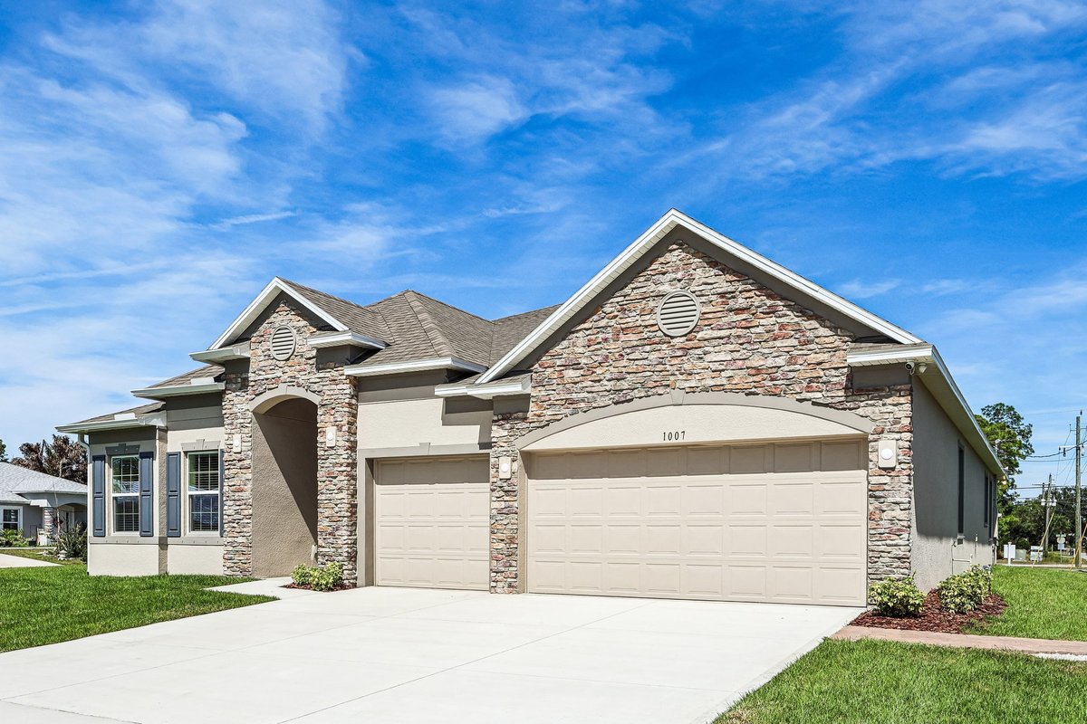 Front exterior of a Maronda Homes property in Palm Bay FL with stone facade and three-car garage