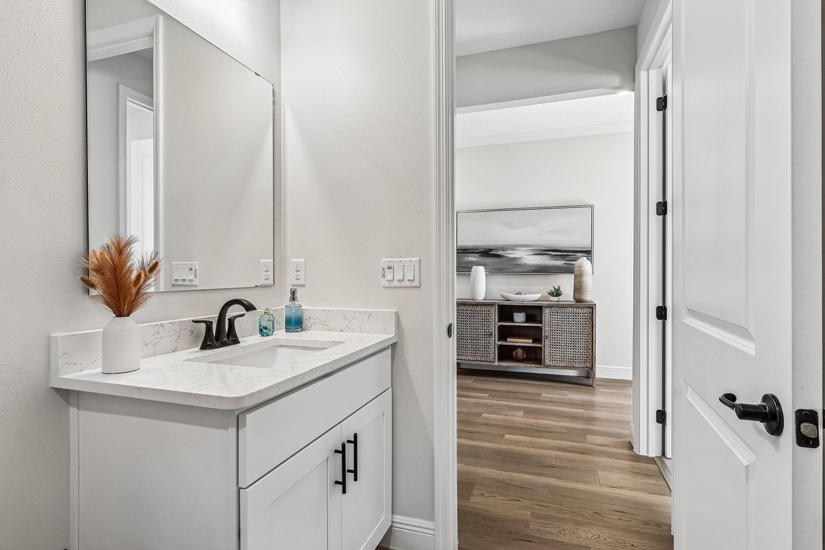 Bathroom with tub shower, tile wall, and white vanity in Palm Bay FL home