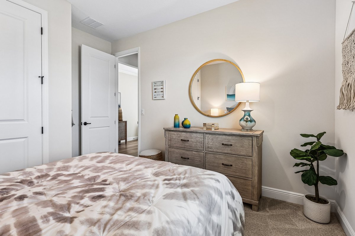 Staged bedroom with coastal artwork and neutral decor in Palm Bay FL