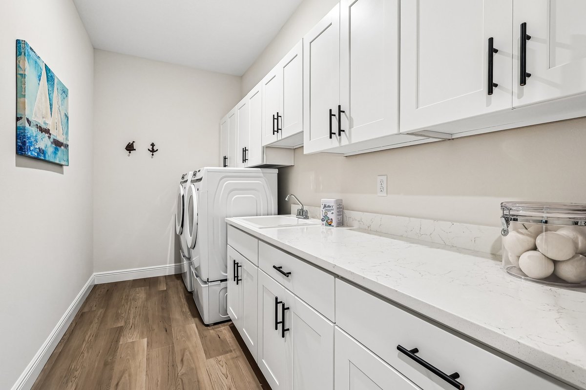 Laundry room with white cabinets, washer dryer, and countertop in Palm Bay FL home