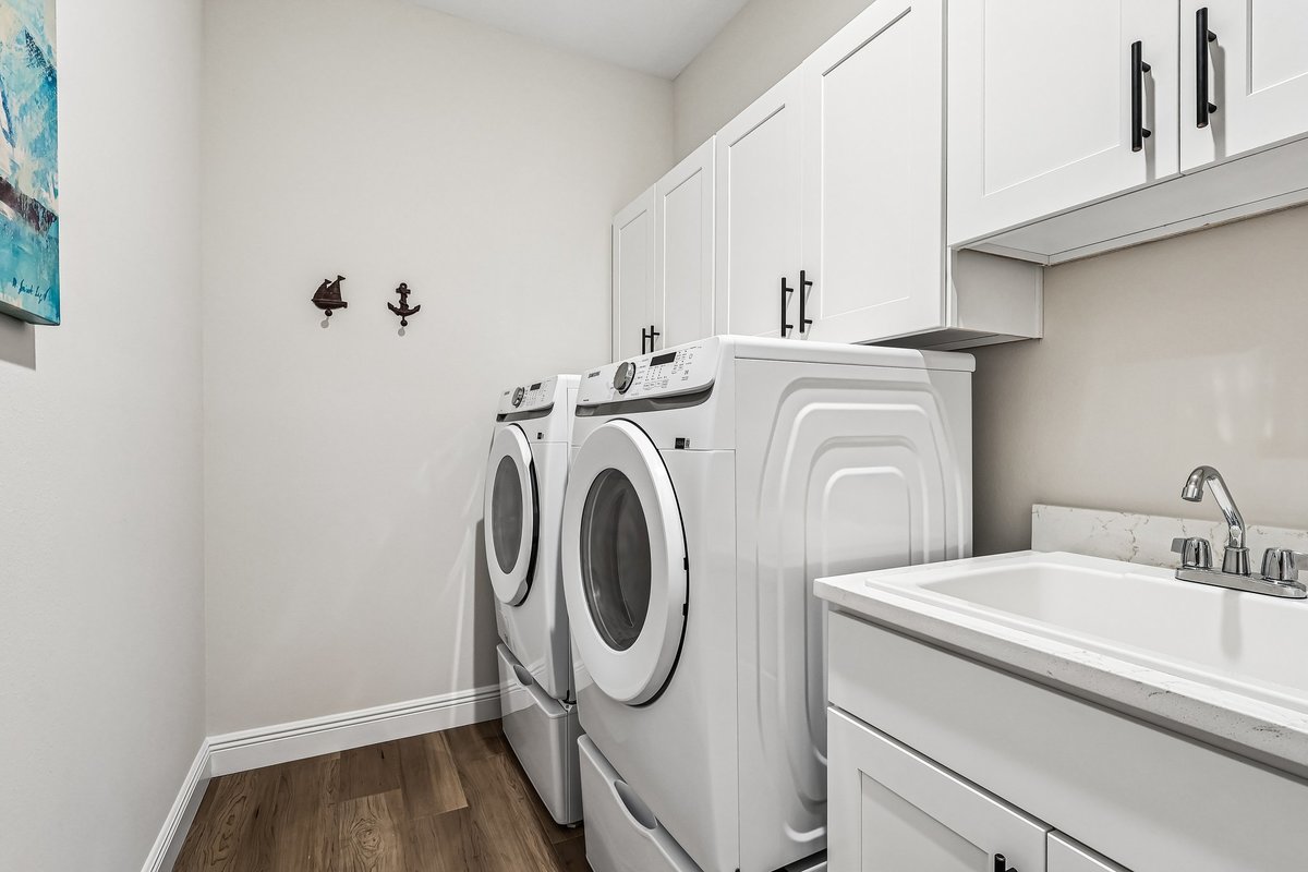 Laundry room with white cabinets, washer dryer, and countertop in Palm Bay FL home