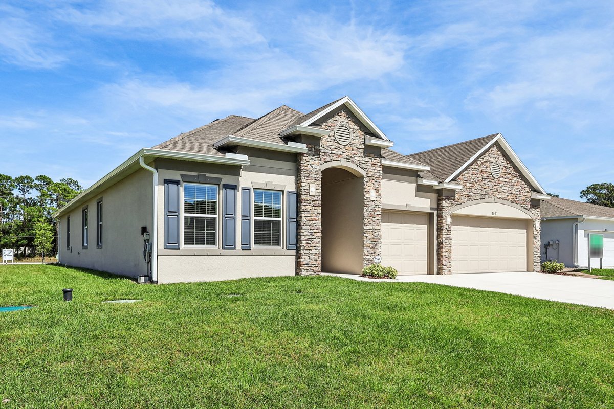 Front exterior of a Maronda Homes property in Palm Bay FL with stone facade and three-car garage