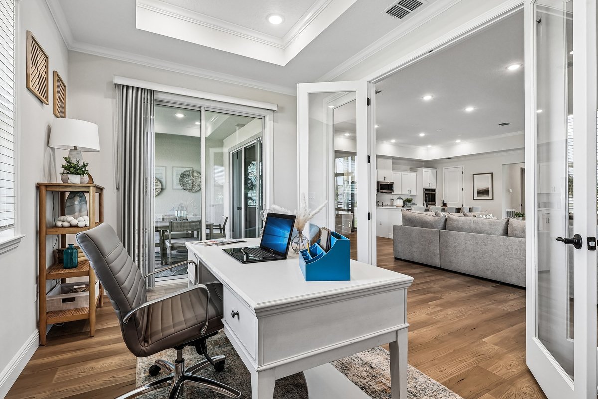 Home office with glass doors and view into open living area in Palm Bay FL
