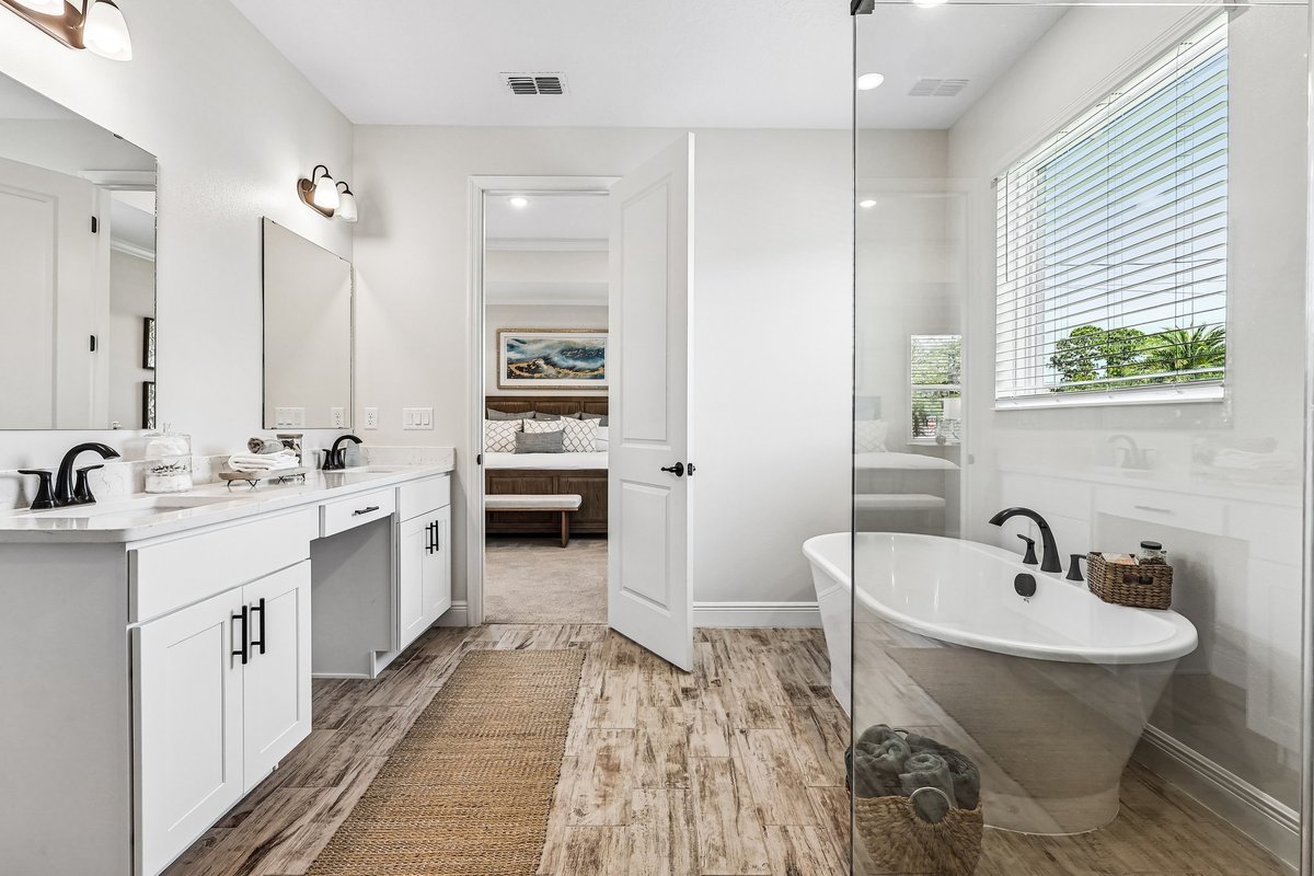 Primary bedroom with tray ceiling, wood bed, and natural light in Palm Bay FL