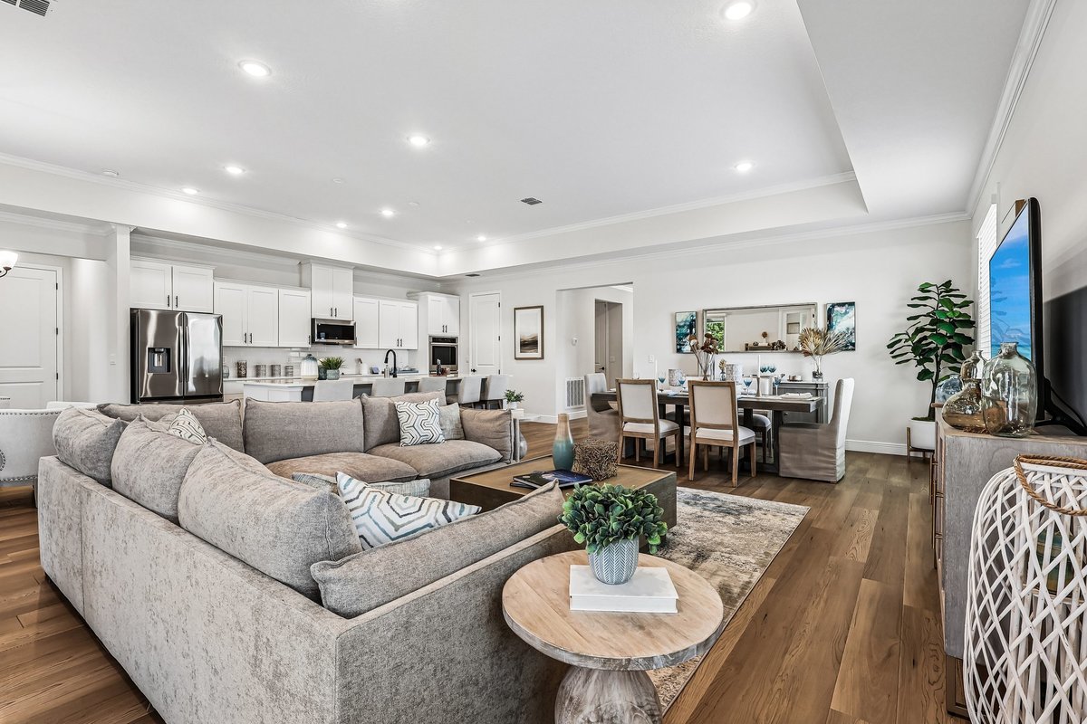 Open living room with sectional sofa and kitchen connection in Palm Bay FL home