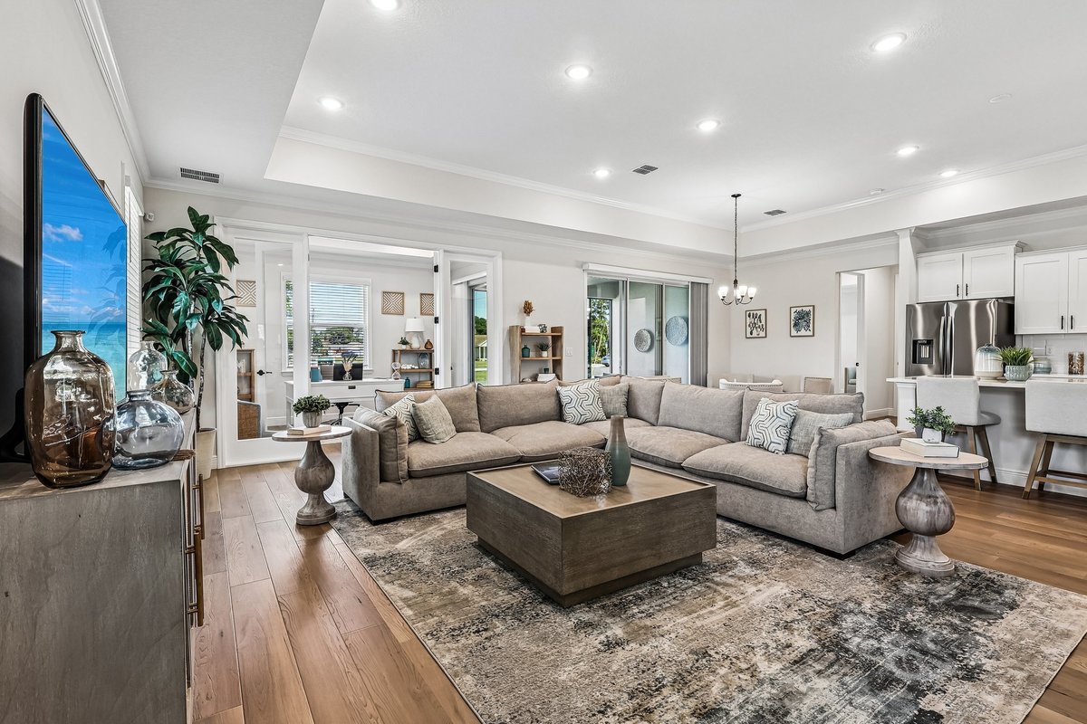 Open living room with sectional sofa and kitchen connection in Palm Bay FL home