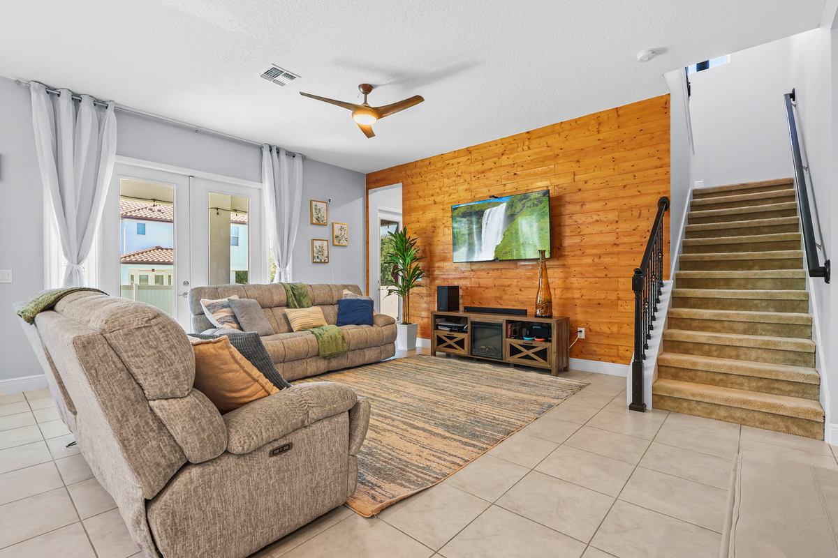 The living room highlights warmth, depth, and the home’s family-focused layout.