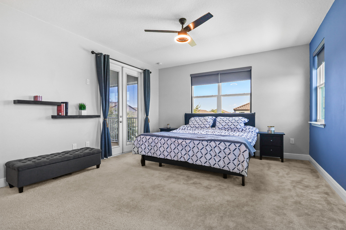 The primary bedroom shows scale, natural light, and access to outdoor space.