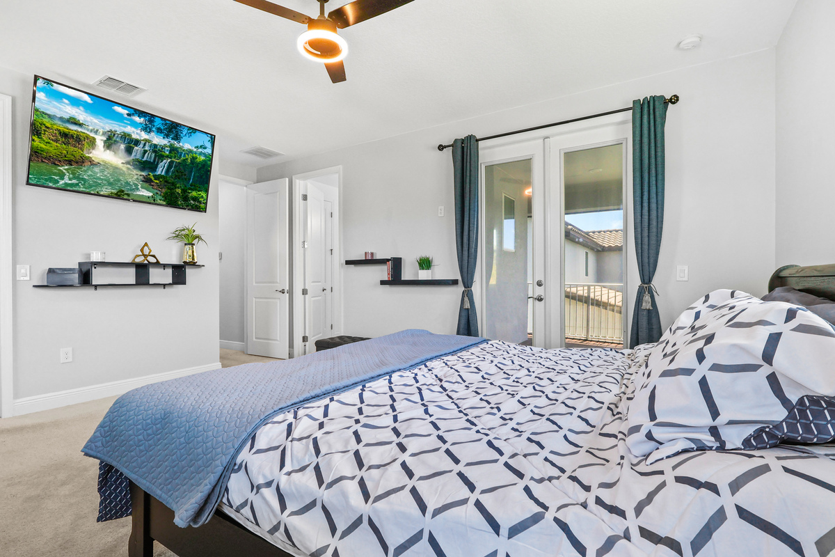 The primary bedroom shows scale, natural light, and access to outdoor space.