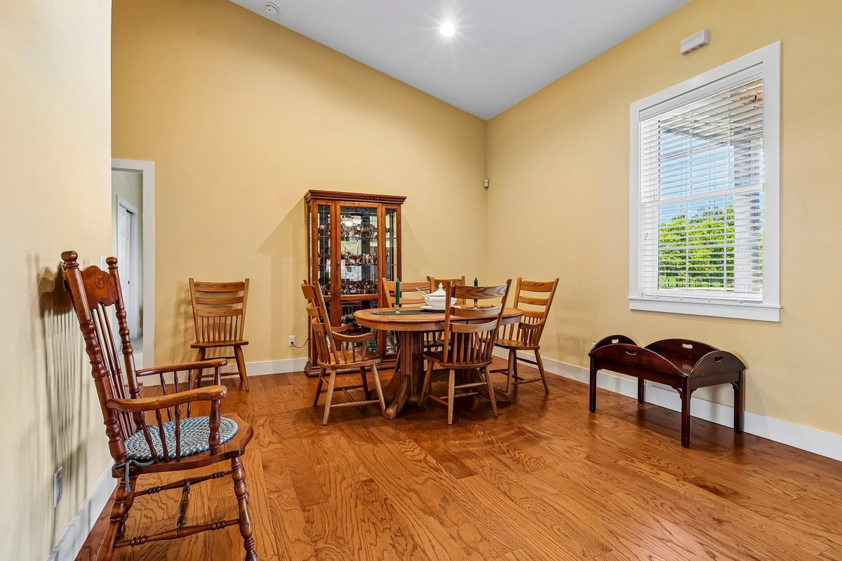 Dining room with wood table, high ceilings, yellow walls, and natural light in Haines City home