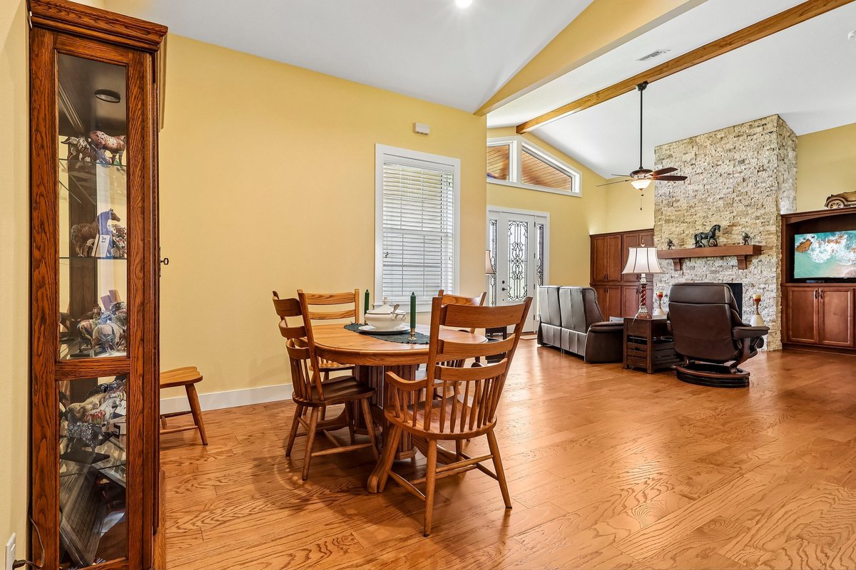 Dining room with wood table, high ceilings, yellow walls, and natural light in Haines City home