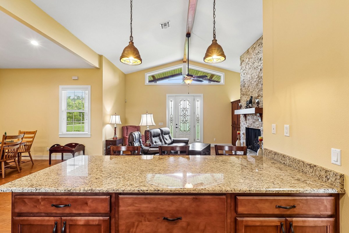 Kitchen countertop view looking toward living room and fireplace in Haines City acreage home