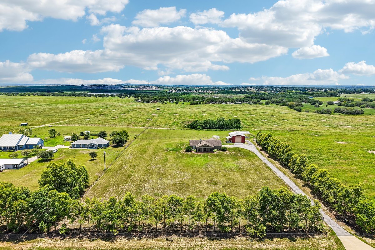 Drone overview of Haines City acreage property with open land, home, workshop, and driveway
